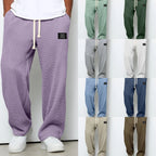 Sage green waffle-knit wide-leg pants worn with white sneakers against a plain studio backdrop