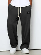 Charcoal black waffle-knit wide-leg pants shown from the front against plain grey backdrop