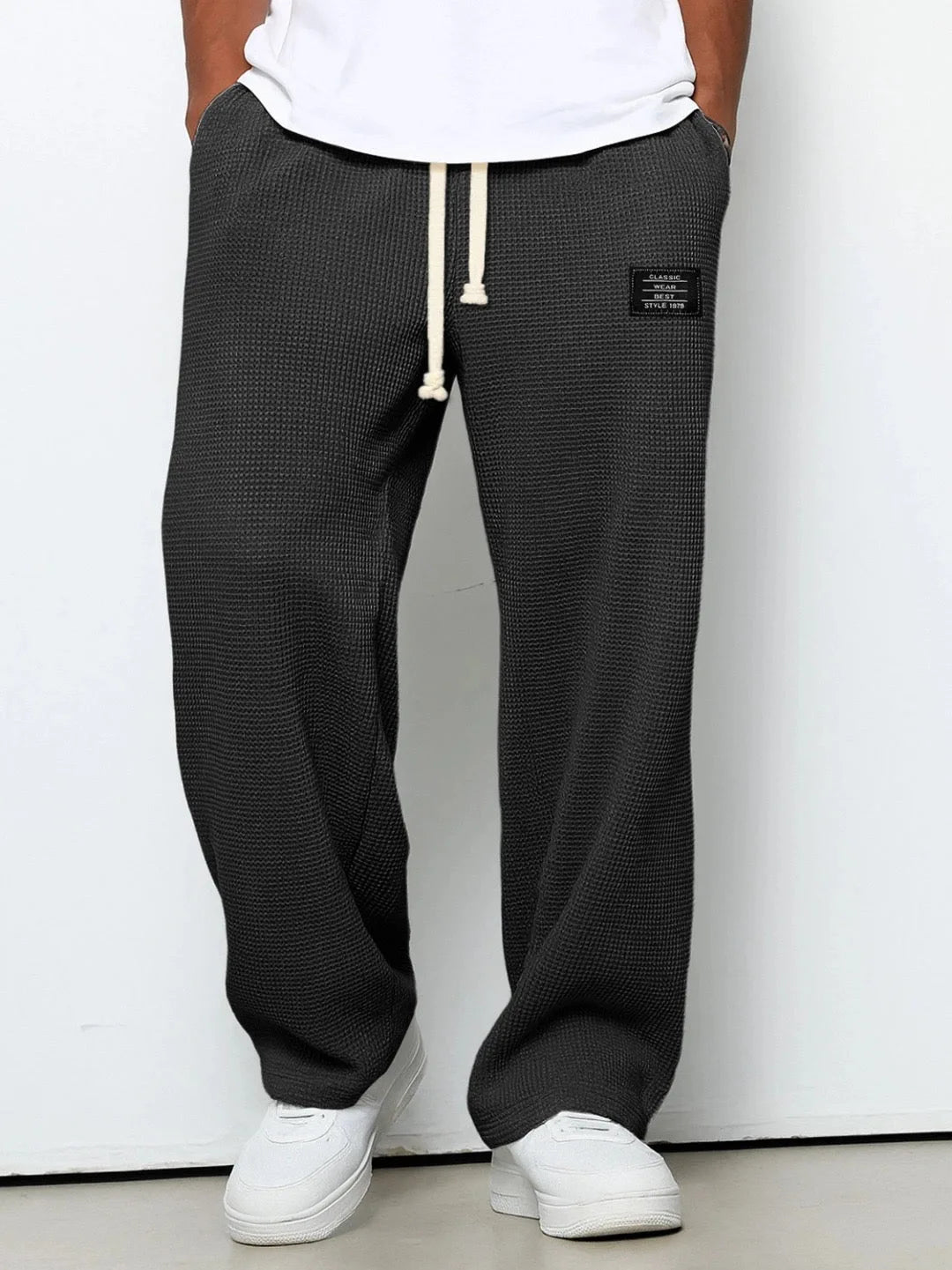 Charcoal black waffle-knit wide-leg pants shown from the front against plain grey backdrop