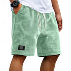 Sage green textured waffle shorts on a model, side angle highlighting slanted pocket and loose fit