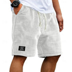 Off-white waffle shorts on a model, side angle showing textured knit fabric and elastic drawstring waist