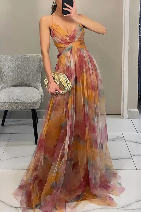 Side view of a flowing multicolour maxi dress with pleated skirt and spaghetti straps, paired with a metallic clutch