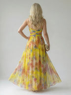 Back view of the yellow multicolour maxi dress showing the crossed waist straps and open back detail