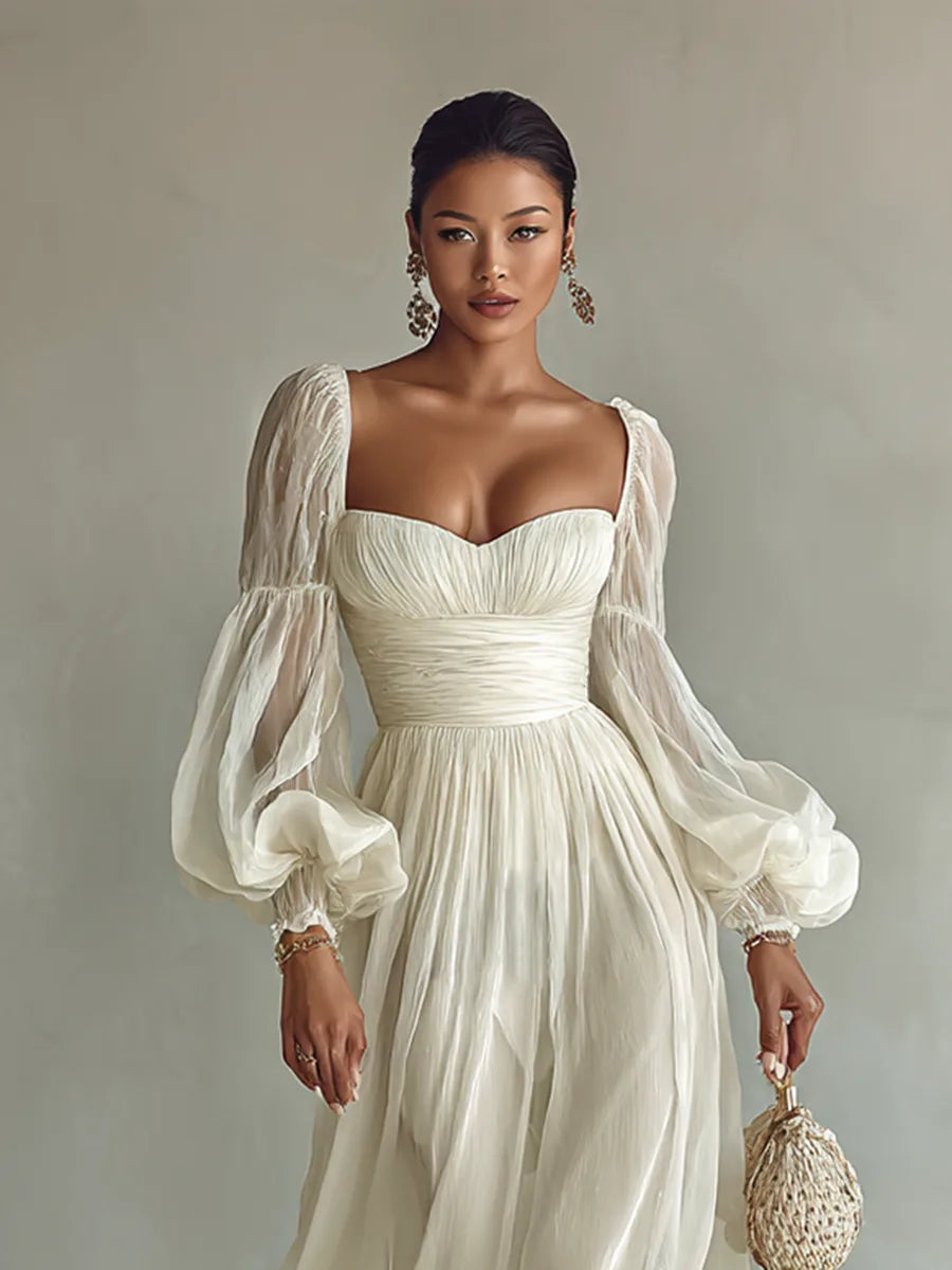 Close front view of the square sweetheart neckline, ruched bodice and sheer puff sleeves on a white chiffon maxi dress