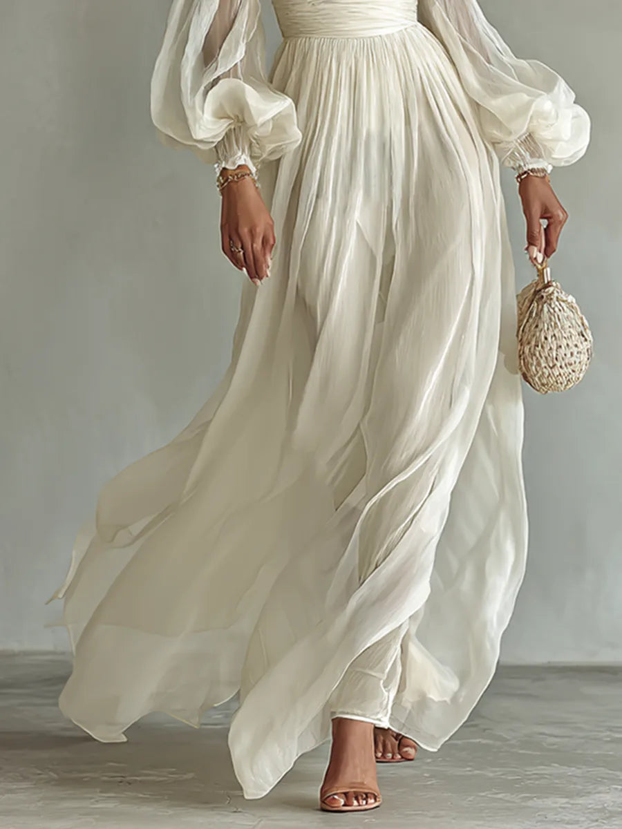 Close-up of the flowing chiffon skirt panels and gathered waistband, showing the dress falling to ankle length