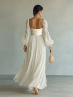 Back view of the white chiffon maxi dress showing the low square back, ruched waistband and sheer bishop sleeves