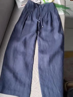 Navy blue wide-leg pants with elasticated pintuck waistband and drawstring, laid flat