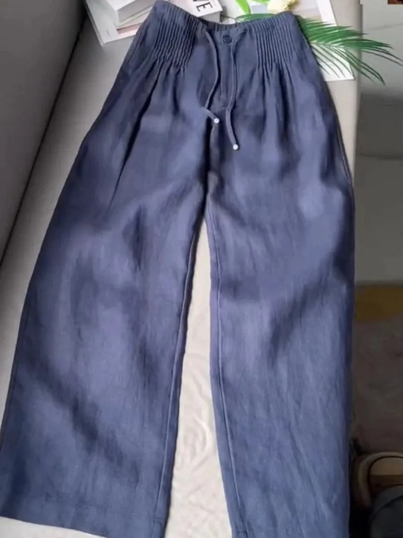 Navy blue wide-leg pants with elasticated pintuck waistband and drawstring, laid flat
