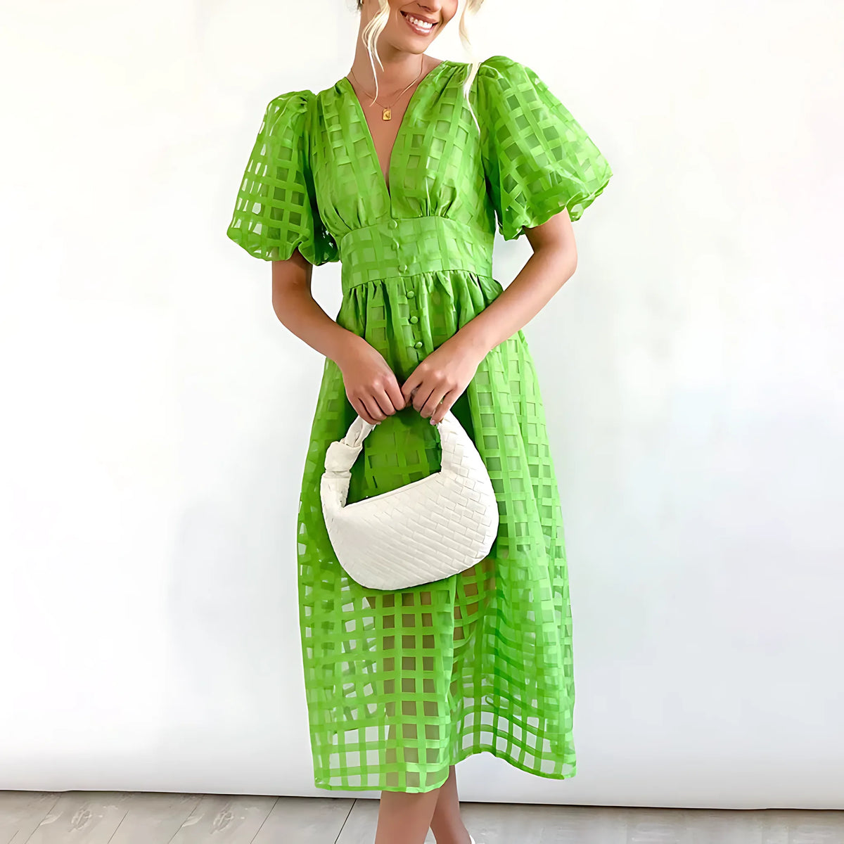 Bright green windowpane-check midi dress with puff sleeves and button-front detailing, worn with a white woven bag.
