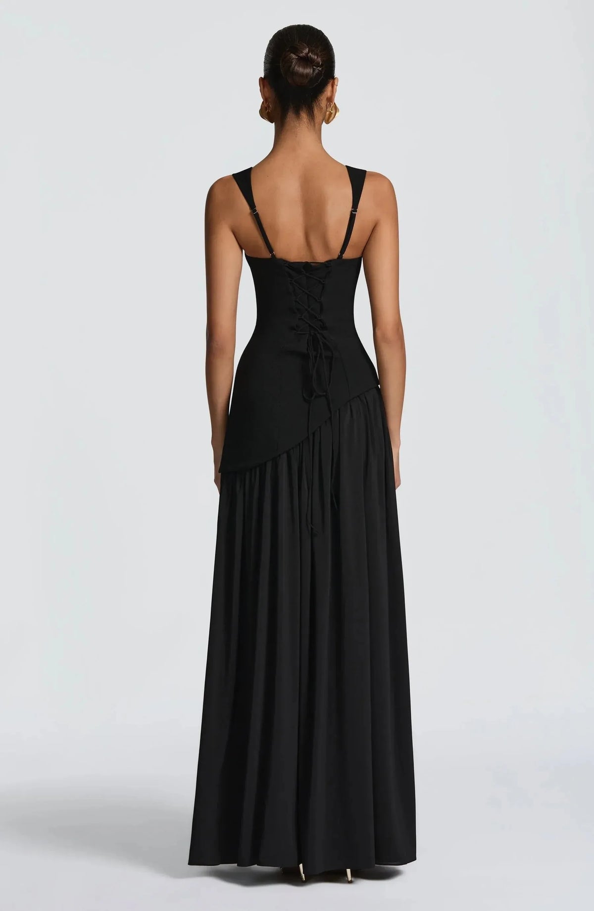 Back view of the black maxi dress showing adjustable straps and a lace-up corset-style back closure