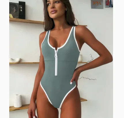 Sage green one-piece swimsuit with white contrast trim and front zip, square neckline, studio shoot