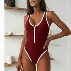 Deep red one-piece swimsuit with white contrast trim and front zip, high-leg fitted silhouette