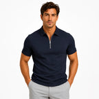 Close-up front view of a man wearing a light blue zip-neck polo shirt highlighting the pique fabric texture and collar shape
